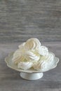 Delicate white french meringue cookies on grey background.
