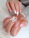 Delicate white and pink manicure with gold design. Shiny gold design.