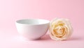 Delicate White Rose Beside Empty Bowl on Pink Background Royalty Free Stock Photo