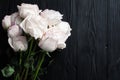 Delicate white roses on black wooden background close up, beautiful light pink flowers bouquet on dark gray wood, greeting card Royalty Free Stock Photo