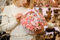 Delicate white wicker basket with small pink roses inside in hands of woman Royalty Free Stock Photo