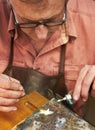 This is delicate work - Jewelry manufacturing. Cropped view of a manufacturing jeweler at work with a small blow torch.