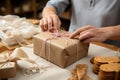 Delicate wrapping: Close-up reveals confectioner\'s hands carefully adorning cardboard box with finesse.