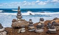 Delicately balanced man made stacks or piles of stones with crashing waves Royalty Free Stock Photo