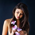 Delicately beautiful. a beautiful young woman posing against a dark background.