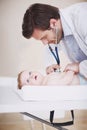 Delicately examining her little body. A male doctor examining an infant girl with his stethoscope. Royalty Free Stock Photo