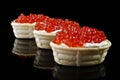 Red caviar in tartlet, isolated over black