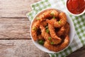 Delicatessen shrimp in coconut breaded closeup in bowl and tomato sauce. horizontal top view