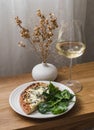 Delicious aperitif, appetizer - gorgonzola, pear pizza, spinach and a glass of white wine on a wooden table Royalty Free Stock Photo