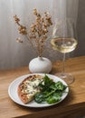 Delicious aperitif, appetizer - gorgonzola, pear pizza, spinach and a glass of white wine on a wooden table