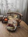 Delicious aperitif, tapas on a round wooden table - two glasses of white wine and a plate with prosciutto, cheese, olives and Royalty Free Stock Photo