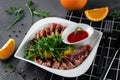 Delicious appetizer with sliced bacon, arugula, orange and red sauce on grey table. Traditional dish menu served in a restaurant Royalty Free Stock Photo