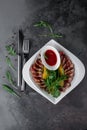 Delicious appetizer with sliced bacon, arugula, orange and red sauce on grey table. Traditional dish menu served in a restaurant, Royalty Free Stock Photo