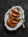 Delicious appetizer, tapas, dessert, snack - baked pumpkin with honey, cinnamon and almond petals on a dark background, top view