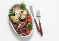 Delicious appetizer, tapas, lunch plate - beef steak, vegetables salad and roasted potatoes with blue cheese on a light background Royalty Free Stock Photo