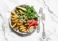 Delicious appetizer, tapas, snack plate - french fries, salmon, arugula, gherkins, olives on a light background, top view Royalty Free Stock Photo