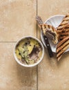 Delicious appetizer, tapas, snack - turkey liver pate with fragrant herbs and crispy grilled bread on a stone beige background,
