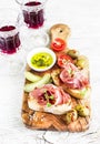 Delicious appetizer to wine - toast with ham, olives, tomatoes Royalty Free Stock Photo