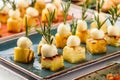 Delicious appetizers with cheese and pineapple in plate on banquet table. Catering food, canape and snacks, close up