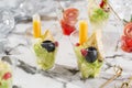 Delicious appetizers in glass cups with lettuce, olives, cheese and orange sauce on marble banquet table. Catering food, canape Royalty Free Stock Photo