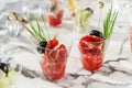 Delicious appetizers in glass cups with prosciutto, olives and tomatoes on marble banquet table. Catering food, canape and snacks. Royalty Free Stock Photo