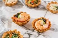 Delicious appetizers in tart with shrimp on marble banquet table. Catering food, canape and snacks, close up.