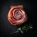 Delicious appetizing jamon rolled up in the shape of a rose on a black background,