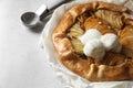 Delicious apple galette served with ice cream on light grey textured table, closeup. Space for text Royalty Free Stock Photo