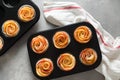 Delicious apple roses puff pastry cakes in tray. Homemade cupcakes with cinnamon recipe. Top view