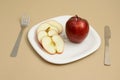 Delicious apple and slice in white plate with knife and fork Royalty Free Stock Photo