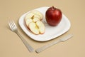 Delicious apple and slice in white plate with knife and fork Royalty Free Stock Photo