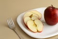 Delicious apple and slice in white plate with knife and fork Royalty Free Stock Photo