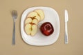 Delicious apple and slice in white plate with knife and fork Royalty Free Stock Photo