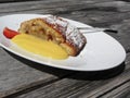 Delicious apple Strudel with vanilla cream on rustic outdoor wooden table at summer . Typical south tyrolean specialty