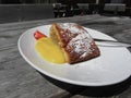 Delicious apple Strudel with vanilla cream on rustic outdoor wooden table at summer . Typical south tyrolean specialty