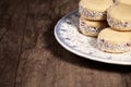 Delicious Argentinian cookies cornflow alfajores with cream dulce de leche close-up . White vanilla macaroons on white