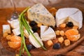 Assorted cheeses and onion on a wooden Board.