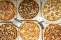 Delicious assorted freshly baked pizzas along with pizza cutters