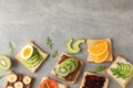 Delicious assorted sandwiches on grey background