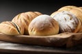 Delicious Assortment of Baked Bread and Rolls on a Rustic Black Bakery Table Counter.