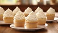 Delicious assortment of freshly baked cupcakes with cream cheese frosting on pristine white table