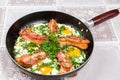 Delicious bacon strips, sausages and fried eggs breakfast in pan Royalty Free Stock Photo