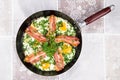 Delicious bacon strips, sausages and fried eggs breakfast in pan Royalty Free Stock Photo