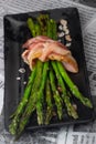 Delicious bacon wrapped asparagus in newspaper background