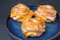 Delicious bagels with ham and cheese on black table, closeup