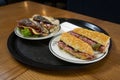 Delicious baguette sandwich with ham and salami served on a plate in a bekery shop in London.