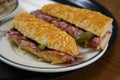 Delicious baguette sandwich with ham and salami served on a plate in a bekery shop in London.