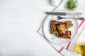 Delicious baked eggplant rolls served on white wooden table, flat lay. Space for text Royalty Free Stock Photo