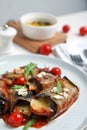 Delicious baked eggplant rolls with tomatoes, cheese and arugula on plate, closeup Royalty Free Stock Photo