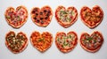 Delicious baked pizzas in the shape of a heart, with various vegetables and sausage, on a white background